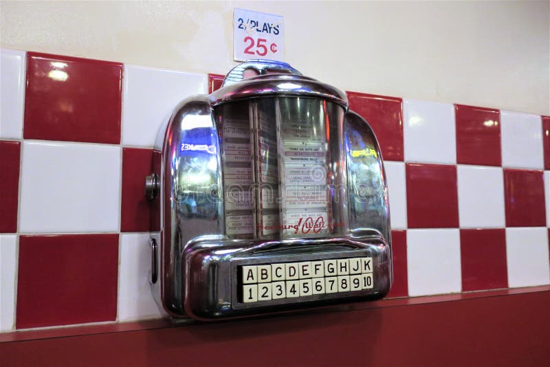 Wall Mounted Vintage Jukebox with a Keypad with Letters and Numbers, with Typewritten Names of Songs and Artists on Paper Cards