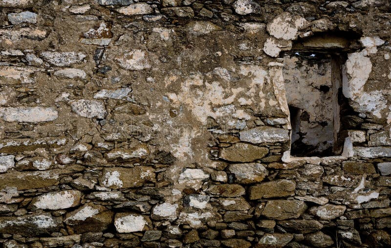 The wall of the old rough stone with a window