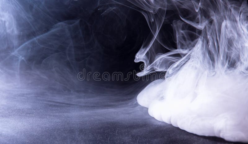 Spread out the vape smoke on the black table. Spread out the vape smoke on the black table