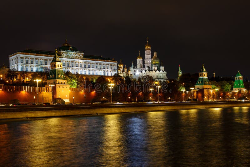 Wall and towers of Moscow Kremlin on a background of Grand Kremlin Palace and cathedrals at night with illumination