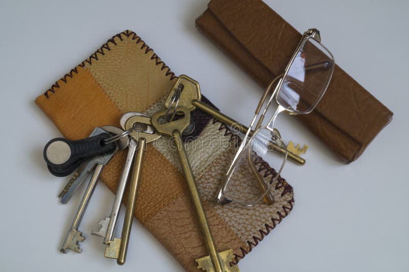 Wallet made of scraps of leather, a bunch of keys and glasses-attributes of a business person. Wallet made of scraps of leather, a bunch of keys and glasses-attributes of a business person