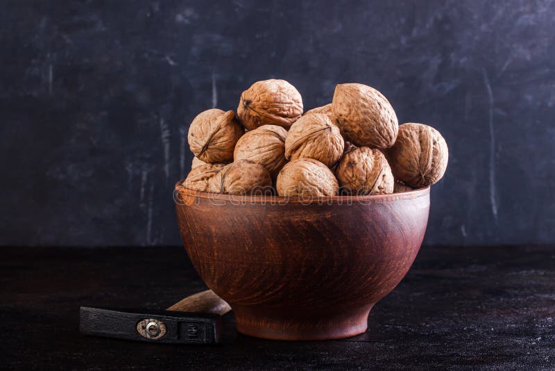 Walnut in a Clay Bowl and a Gout on a Concrete Background Stock Photo