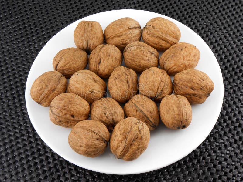 Walnuts on a white plate stock image. Image of dried 35833493