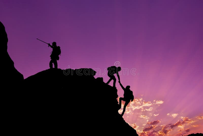 Wandelaars die op rots, berg bij zonsondergang, één beklimmen van hen die hand geven en helpen te beklimmen Groepswerk, Hulp, Suc