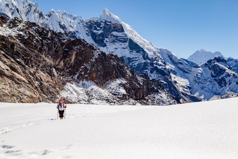 Wandelende Vrouw die Cho La Pass in de Berg s, Nepal kruisen van Himalayagebergte royalty-vrije stock fotografie Wandelende Vrouw die Cho La Pass in de Berg s, Nepal kruisen van Himalayagebergte royalty-vrije stock fotografie