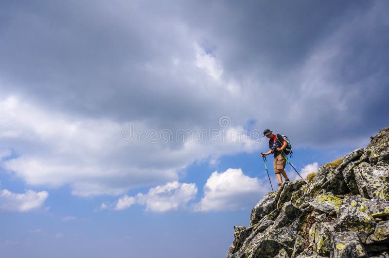 Wanderer mit dem Rucksack, der von der Spitze des Berges absteigt. stockbild Wanderer mit dem Rucksack, der von der Spitze des Berges absteigt. stockbild