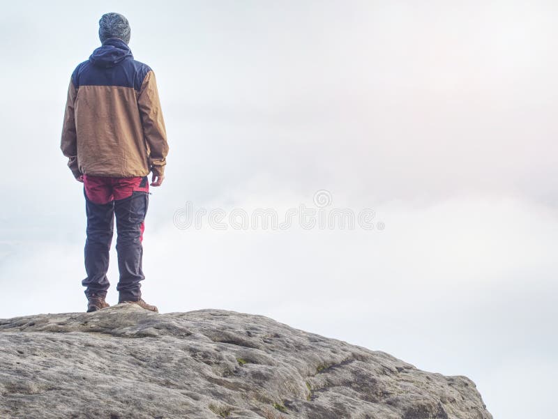 Wanderung in braunen, roten Outdoor-Kleidung mit Blick auf niedrige Wolken lizenzfreie stockfotografie Wanderung in braunen, roten Outdoor-Kleidung mit Blick auf niedrige Wolken lizenzfreie stockfotografie