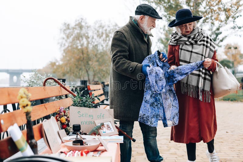 Attentive blonde woman looking at blue scarf stock photography Attentive blonde woman looking at blue scarf stock photography