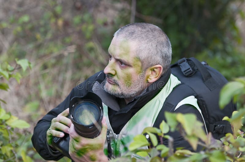 War photographer camouflaged in the vegetation