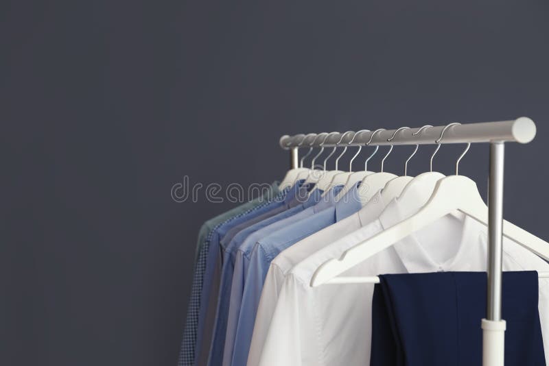 Wardrobe Rack with Men`s Clothes Against Grey Background. Stock Image