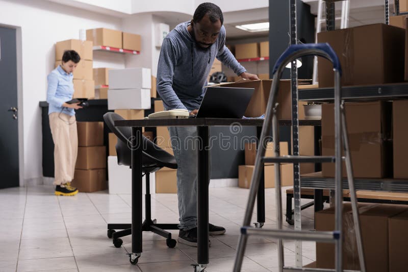 Warehouse Employee Analyzing Transportation Logistics on Laptop