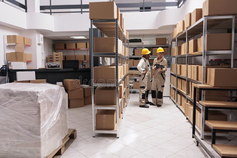 Warehouse employees scanning goods, tracking parcel in tablet software stock image