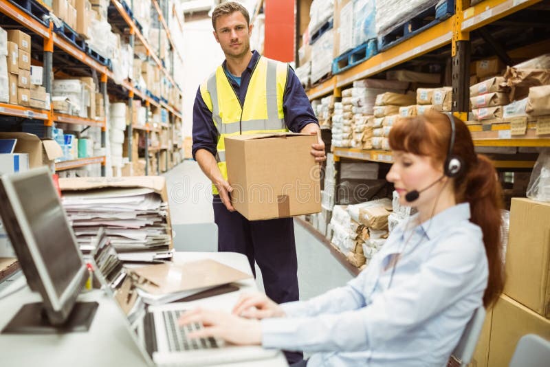 Warehouse manager wearing headset using laptop royalty free stock images Warehouse manager wearing headset using laptop royalty free stock images