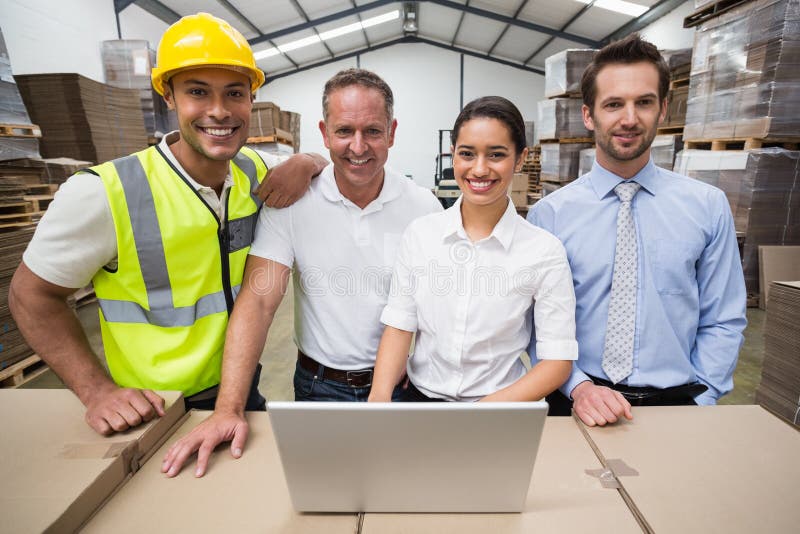 Warehouse managers and worker smiling at camera stock image