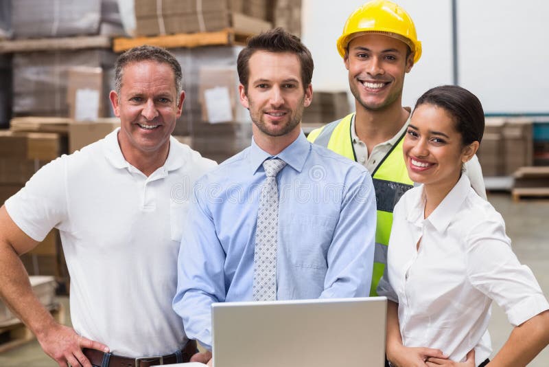 Warehouse managers and worker smiling at camera stock photography