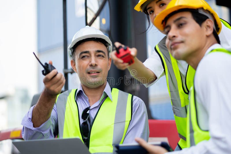 Warehouse managers and worker working on laptop in a large warehouse. They Work at the Heavy Industry Manufacturing Facility stock photography