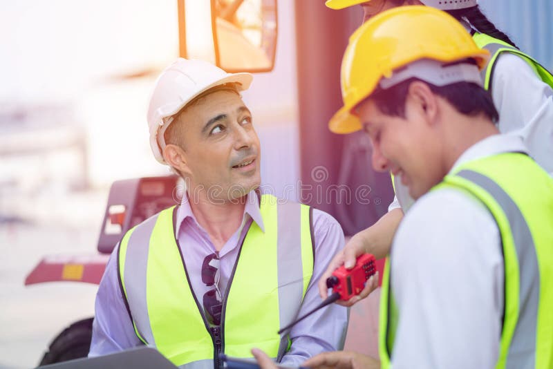 Warehouse managers and worker working on laptop in a large warehouse. They Work at the Heavy Industry Manufacturing Facility royalty free stock images