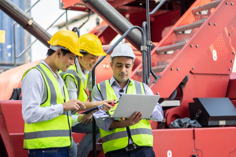 Warehouse managers and worker working on laptop in a large warehouse. They Work at the Heavy Industry Manufacturing Facility stock photo