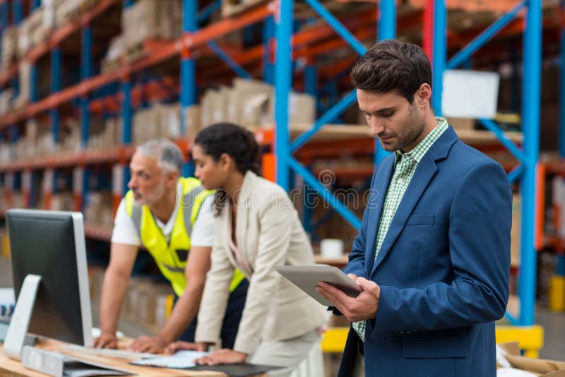 Warehouse managers and worker working together stock images