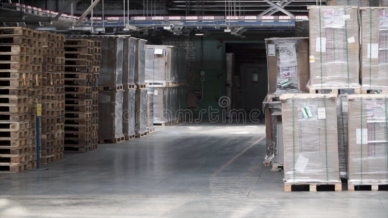 Warehouse with racks and shelves, filled with cardboard boxes, wrapped in foil on wooden pallets. Clip. Large and light stock images Warehouse with racks and shelves, filled with cardboard boxes, wrapped in foil on wooden pallets. Clip. Large and light stock images