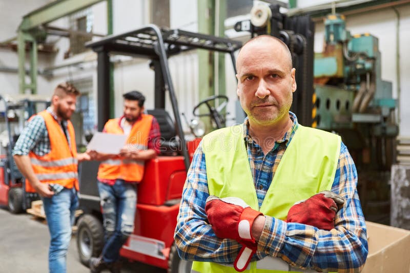 Warehouse Worker As a Forklift Driver in Front of a Forklift Stock