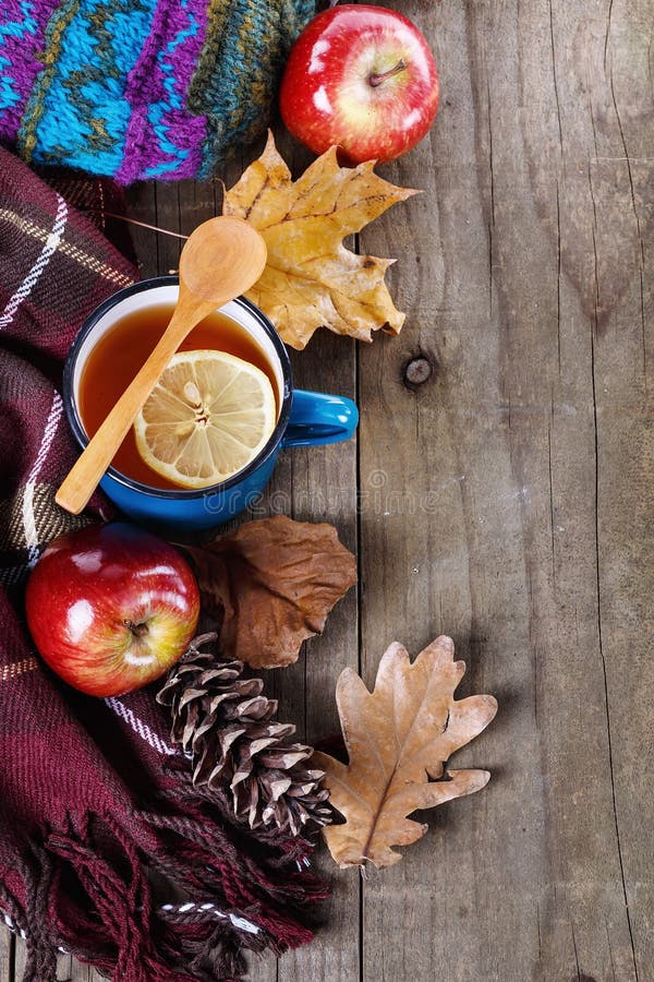 Warm clothing and lemon tea over rustic wooden background