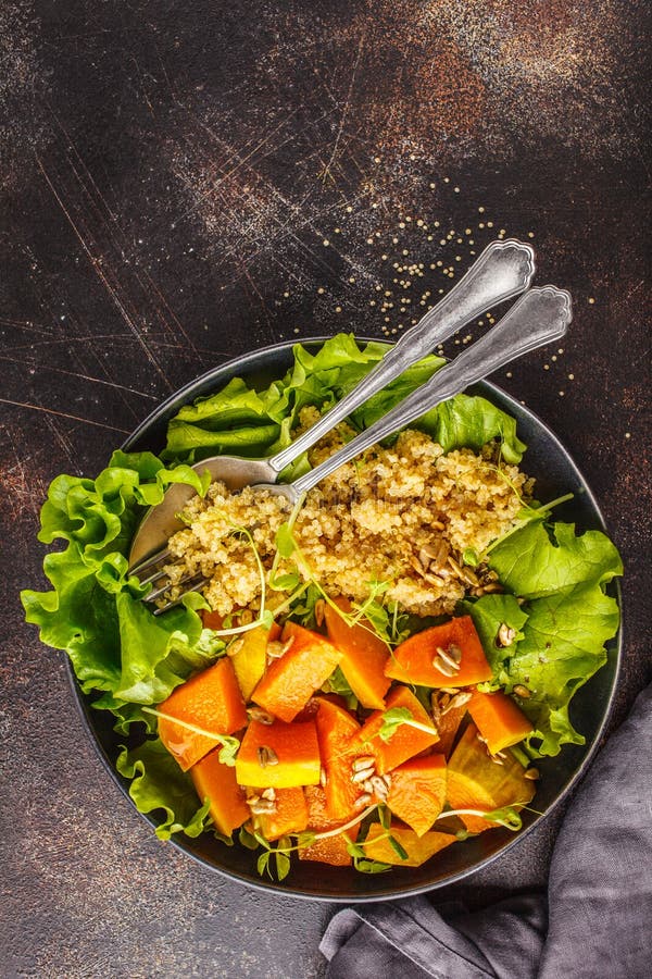 Warm quinoa and pumpkin salad in a white plate on dark background, top view. royalty free stock images Warm quinoa and pumpkin salad in a white plate on dark background, top view. royalty free stock images