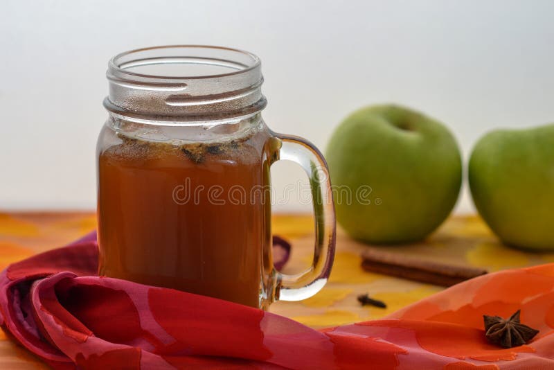 Warm spiced apple cider on table