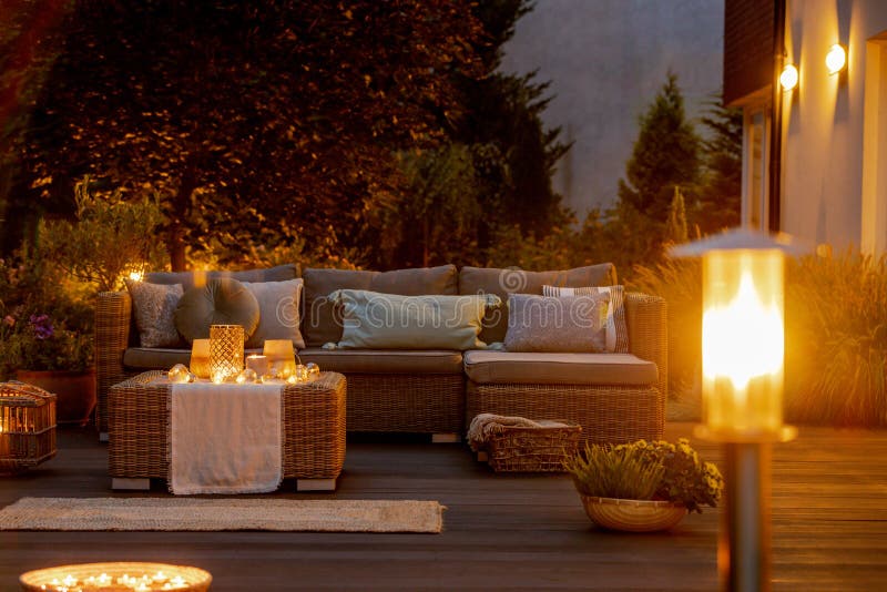 Summer night in the garden with trendy furniture, lights, lanterns and candles