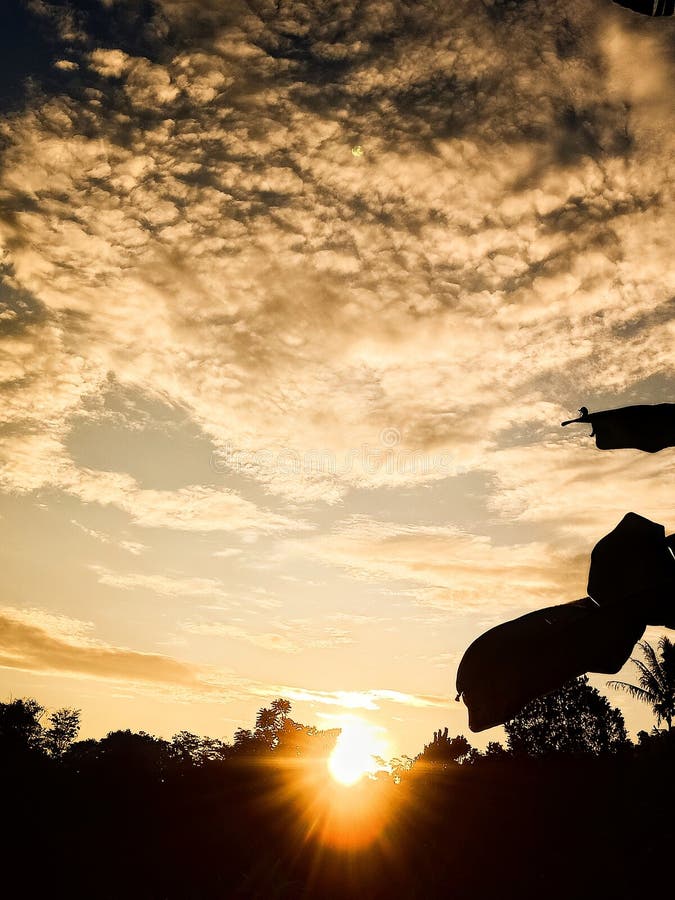 Warm sunlight shines through the clouds, creating a golden, dramatic hue. stock photography