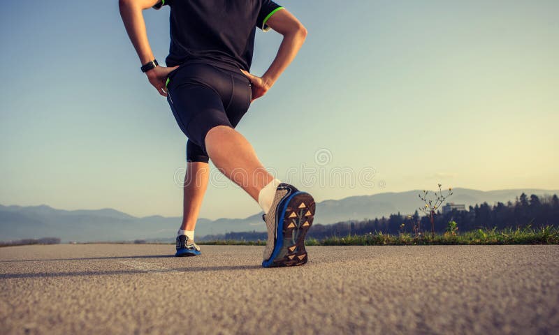 Warming up runner on the road close up image stock photo