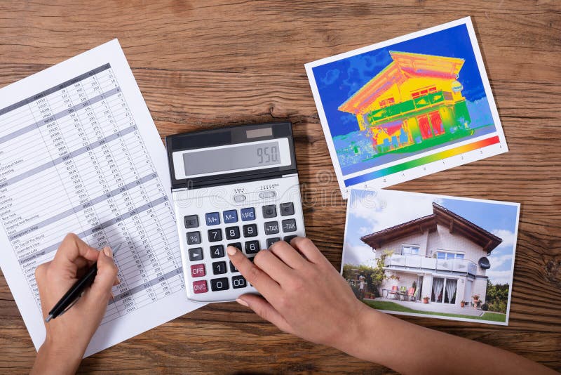 Close-up Of A Person Calculating The Heat Loss And Energy Efficiency Of A House. Close-up Of A Person Calculating The Heat Loss And Energy Efficiency Of A House