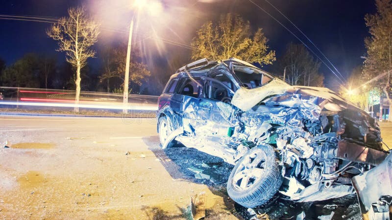 Warnendes Dreieck und Treiber in einer reflektierenden Sicherheit bekleiden nahe dem unterbrochenen Auto Zerschmettertes Auto auf