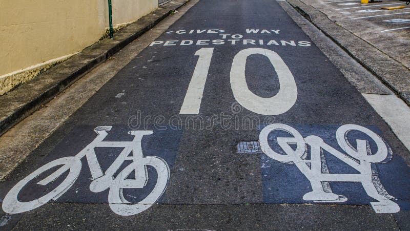 Warning sign for a cyclist to give way to pedestrians and speed limit, not over 10 km/h, it shows painted on the road. stock image Warning sign for a cyclist to give way to pedestrians and speed limit, not over 10 km/h, it shows painted on the road. stock image