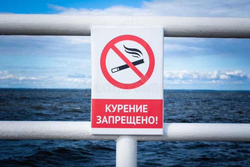 Warning sign on russian language on a sea background : No smoking.