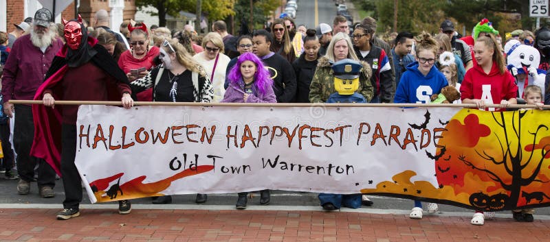Warrenton, Virginia/USA-10/28/18: Tłumu przewożenia sztandar przy Halloweenową Happyfest paradą w Starym Grodzkim Warrenton zdjęcia royalty free Warrenton, Virginia/USA-10/28/18: Tłumu przewożenia sztandar przy Halloweenową Happyfest paradą w Starym Grodzkim Warrenton zdjęcia royalty free