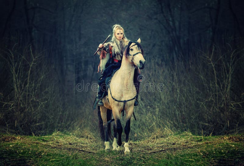 Warrior Woman on a horse in the woods. beautiful scandinavian viking riding horse with ax in hand royalty free stock photo Warrior Woman on a horse in the woods. beautiful scandinavian viking riding horse with ax in hand royalty free stock photo