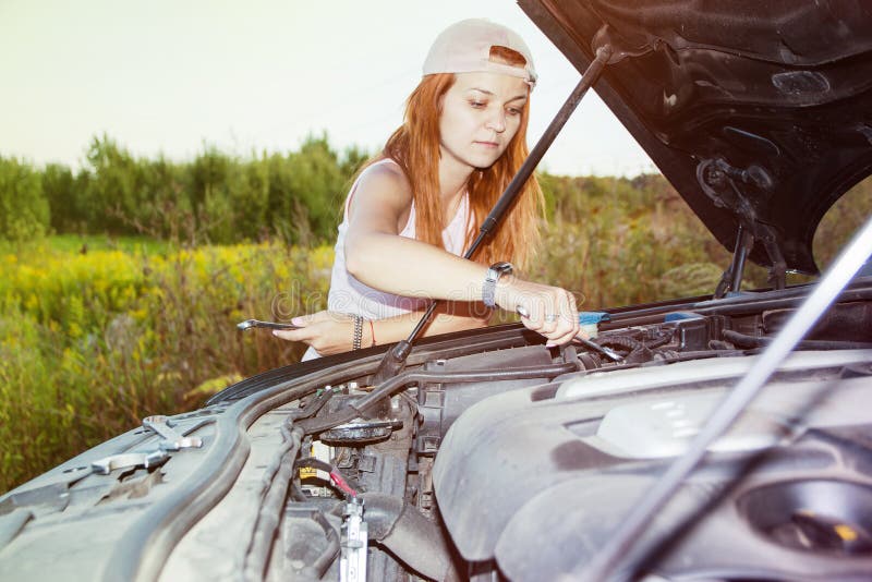 Wartung Pannendienst Porträt einer jungen Frau, die nahe bei ihrem Auto versucht, die Maschine zu reparieren steht stockbild Wartung Pannendienst Porträt einer jungen Frau, die nahe bei ihrem Auto versucht, die Maschine zu reparieren steht stockbild