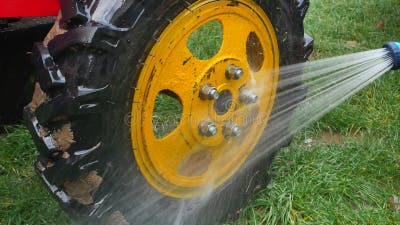 Waschen Sie LKW-Räder Mit Einem Schlauch Mit Wasser. Stock