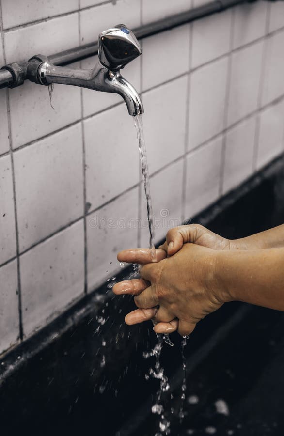 Waschende Hände mit Wasser