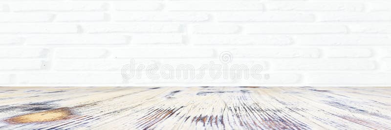 Washed wood table with white brick wall texture background