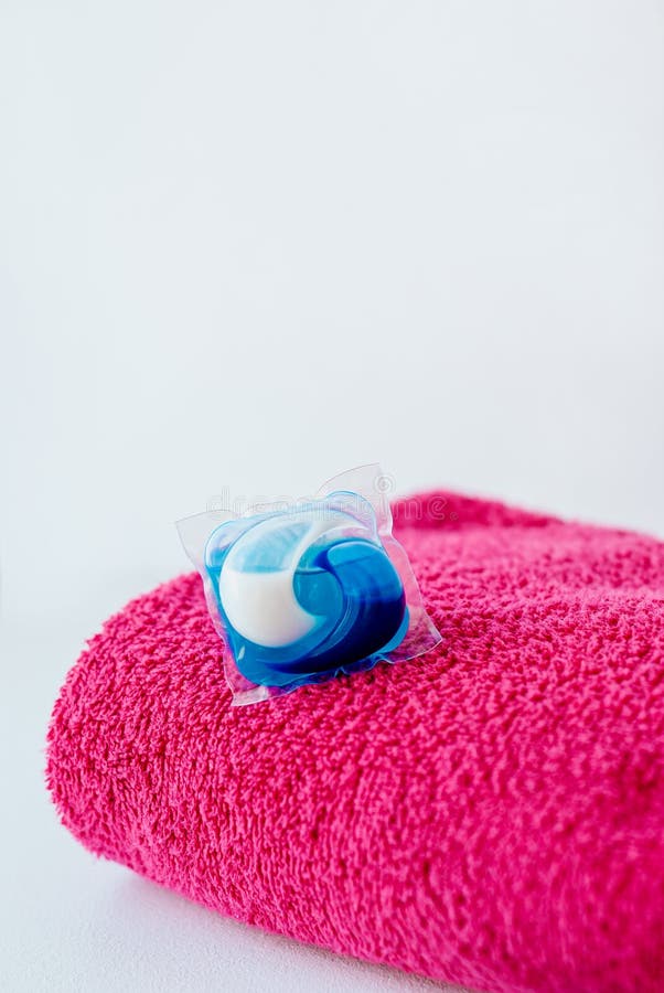 Washing detergent capsule pods and pink towel stock photos Washing detergent capsule pods and pink towel stock photos