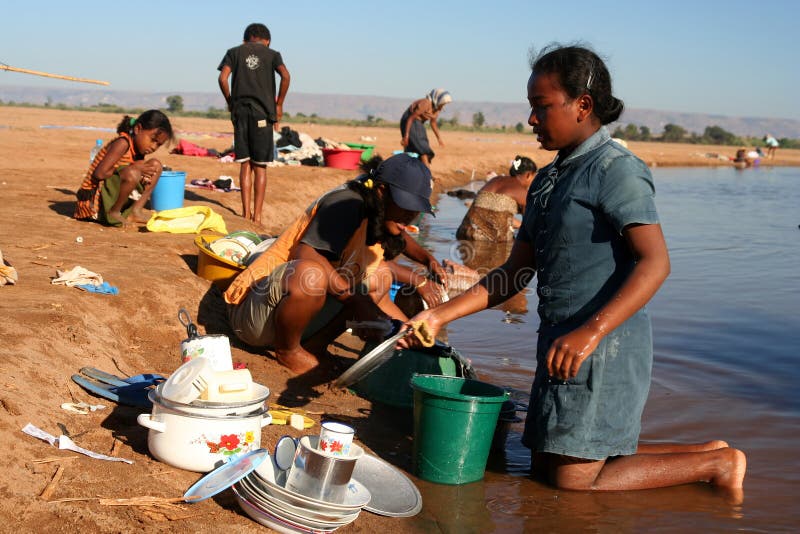 Washing dishes in a river royalty free stock image