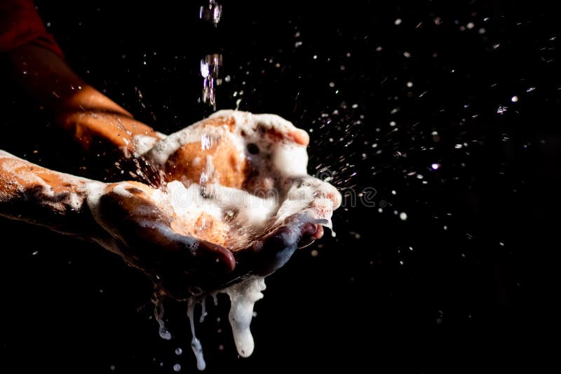 Washing hands.Man washing his hands  on black background.Corona virus pandemic prevention wash hands with soap warm water & rubbing nails & fingers washing frequently.Hygiene & Cleaning Hands