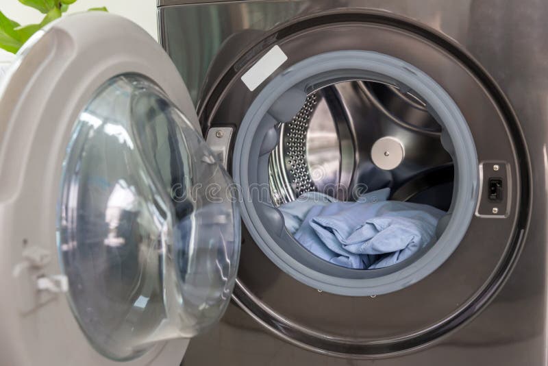 A Washing Machine in Laundry Room. Clothes in Washing Machine. Clothes