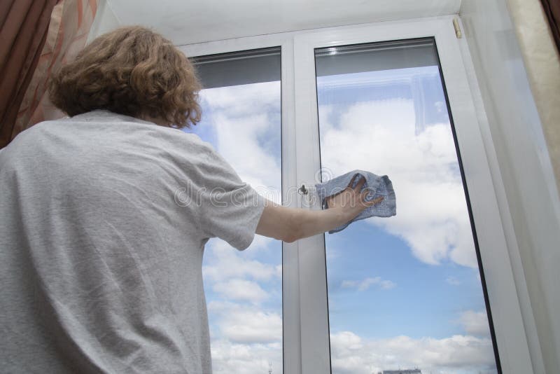 Washing the windows of the house with cleaning agents royalty free stock image
