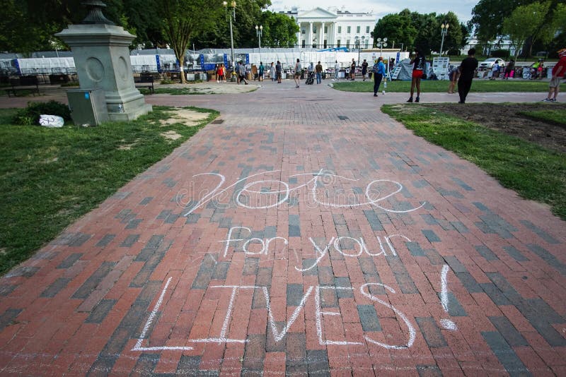 Vote for your lives chalk drawing. WASHINGTON D.C., USA - JUNE 15, 2020: A chalk drawing says, `Vote for your Lives!` leading up to the White House royalty free stock image Vote for your lives chalk drawing. WASHINGTON D.C., USA - JUNE 15, 2020: A chalk drawing says, `Vote for your Lives!` leading up to the White House royalty free stock image