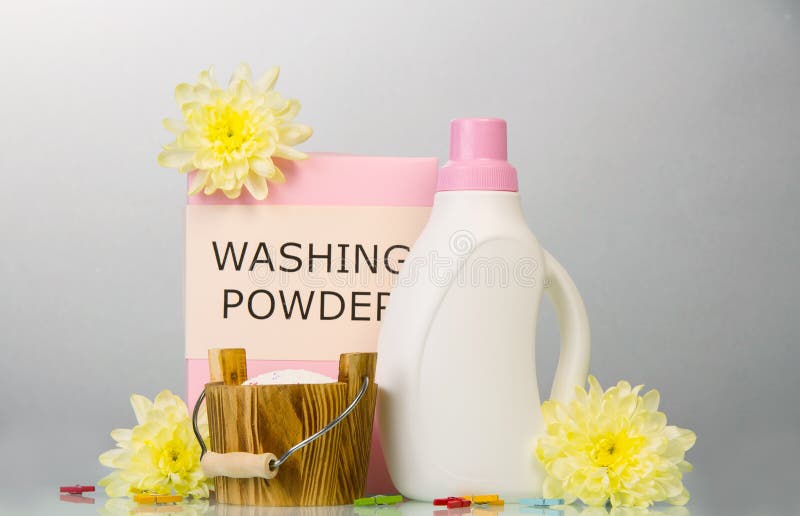 Wasmiddel en wasverzachter op een grijze achtergrond stock afbeelding