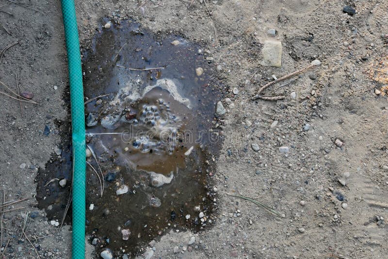 Wasser, das vom Loch in einem Schlauch leckt lizenzfreie stockfotos Wasser, das vom Loch in einem Schlauch leckt lizenzfreie stockfotos