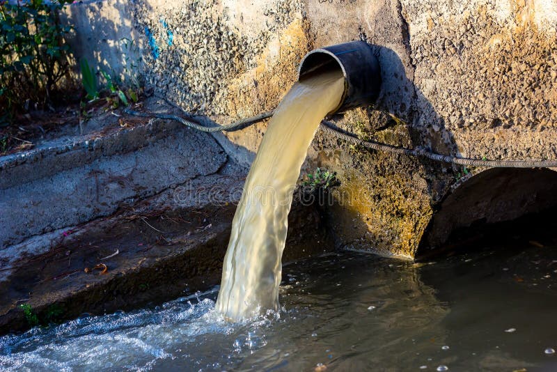 Wastewater sewage pipe dumps the dirty contaminated water into the river. Water pollution, environment contamination royalty free stock image Wastewater sewage pipe dumps the dirty contaminated water into the river. Water pollution, environment contamination royalty free stock image